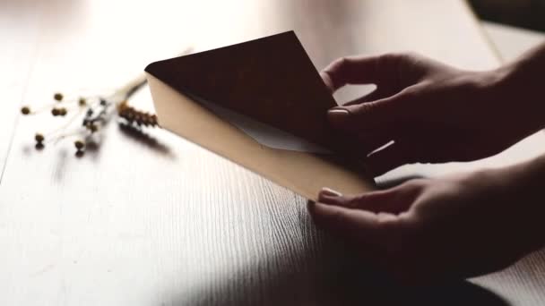 person hands open up kraft envelope with letter on brown background - Footage, Video