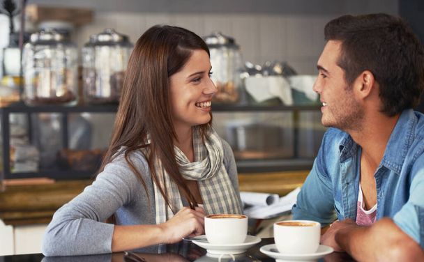 Having an intimate date. A loving young couple at a coffee shop together. - 写真・画像