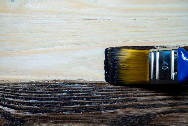 Copy space with paint brush on can lying on wooden background. Close-up paintbrush with liquid dark brown paint on the brush. Painting tools on wooden surface. Top view. Copyspace. Vintage style. - Foto, Bild