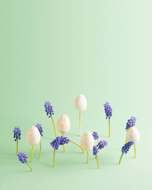 Composición de Pascua. El jacinto púrpura crece a partir de un fondo verde con una sombra en el suelo. Los huevos de Pascua están esparcidos. Copiar espacio. - Foto, imagen
