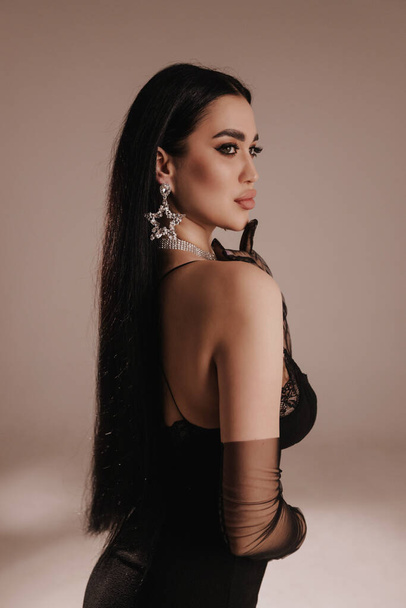 fashion photo of beautiful woman with dark hair in elegant dress posing in studio - Фото, изображение
