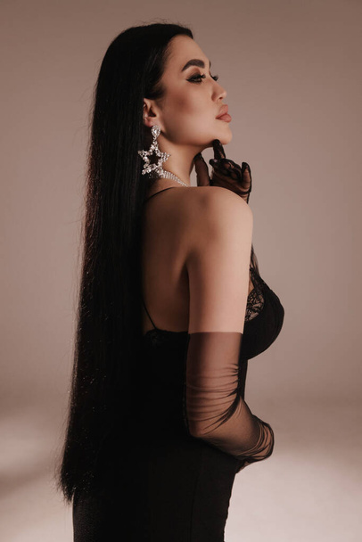 fashion photo of beautiful woman with dark hair in elegant dress posing in studio - Fotoğraf, Görsel