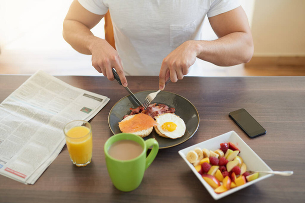 Начни утро правильно. Обрезанный снимок холостяка, завтракающего дома. - Фото, изображение