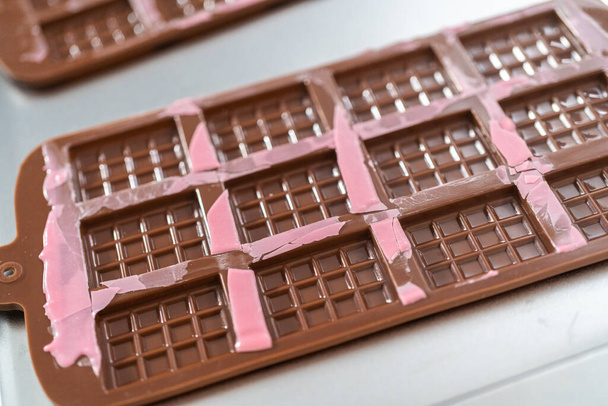 Removing mini pink chocolates from silicone chocolate mold. - Фото, зображення