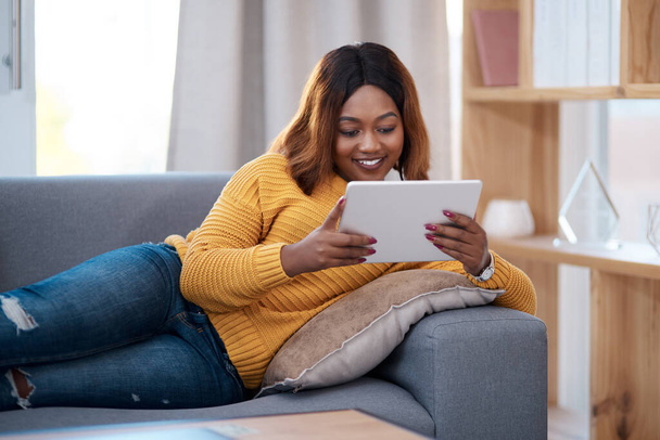 Domov je mé šťastné místo. Snímek atraktivní mladé ženy pomocí digitálního tabletu při relaxaci doma. - Fotografie, Obrázek