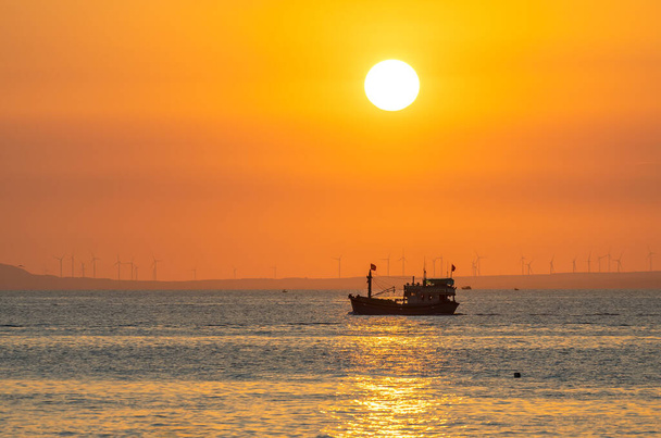 Auringonlasku maisema kun kalastusveneet merellä sadonkorjuuseen päättyy päivä. - Valokuva, kuva