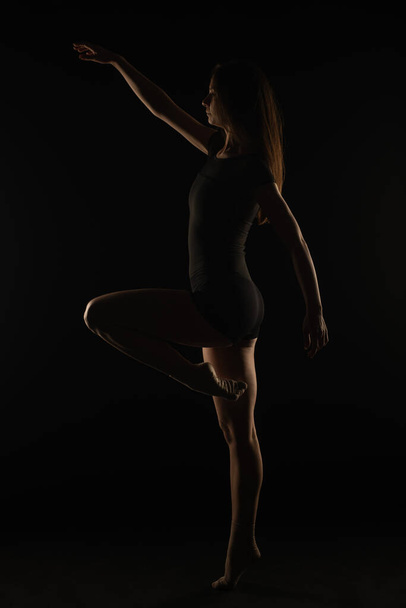 Joven bailarina femenina está sosteniendo una buena postura mientras equilibra n una pierna - Foto, imagen