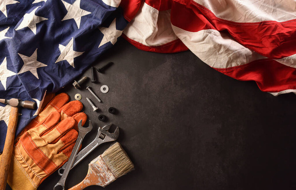 Happy Labor day concept. American flag with different construction tools on dark stone background. - Photo, Image