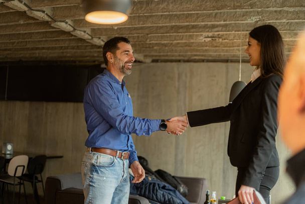 Two amazing and beautiful business people are making a deal with a handshake while smiling - Valokuva, kuva