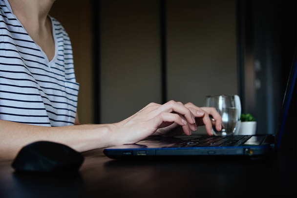 Mujer caucásica escribiendo con teclado portátil en el lugar de trabajo de la oficina en casa. Freelancer trabajando remotamente - Foto, imagen