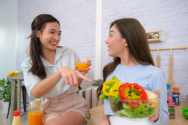 Les jeunes femmes asiatiques couple aiment cuisiner la salade à la maison. - Photo, image