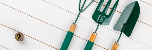 Gardening tools on white wooden background. Flat lay banner.  - 写真・画像