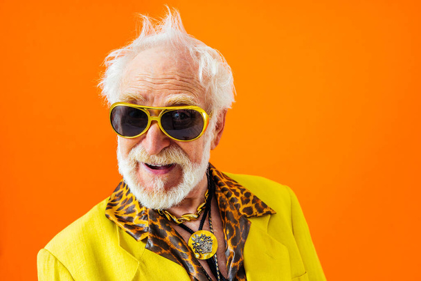 Cool senior man with fashionable clothing style portrait on colored background - Funny old male pensioner with eccentric style having fun - Φωτογραφία, εικόνα