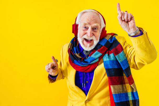Cool senior man met modieuze kleding stijl portret op gekleurde achtergrond - Grappige oude mannelijke gepensioneerde met excentrieke stijl hebben plezier - Foto, afbeelding