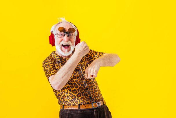 Cool senior man with fashionable clothing style portrait on colored background - Funny old male pensioner with eccentric style having fun - Zdjęcie, obraz