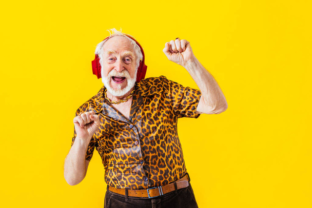 Cool senior man with fashionable clothing style portrait on colored background - Funny old male pensioner with eccentric style having fun - Foto, Bild