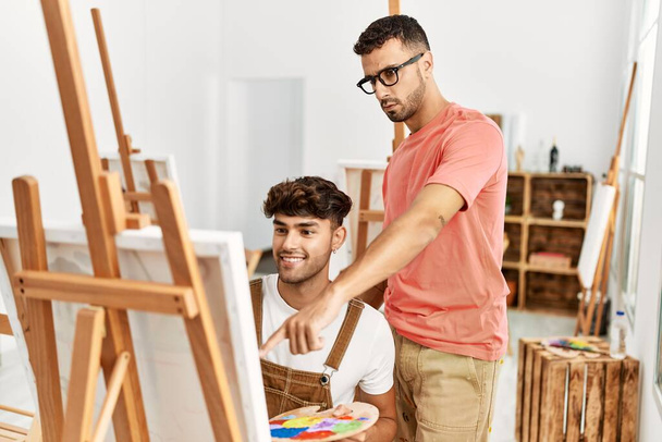 Deux hommes hispaniques professeur et étudiant dessin au studio d'art - Photo, image
