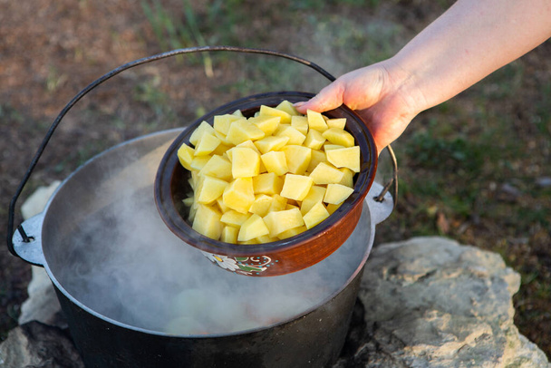 Fischsuppe über offenem Feuer zubereitet. Fischsuppe über offenem Feuer in einem Wasserkocher kochen. Kochen im Wandertourismus und Fischfang - Foto, Bild