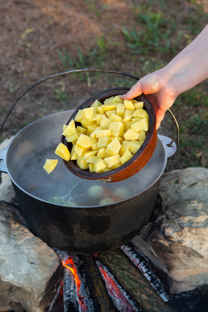 Vissoep bereid boven een open vuur. Vissoep koken boven een open vuur in een ketel. Koken in wandeltoerisme en vissen - Foto, afbeelding
