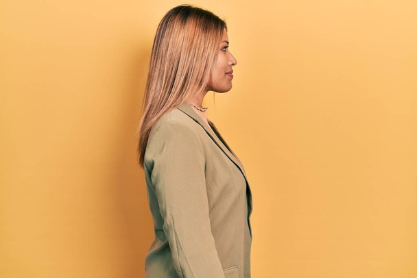 Mulher hispânica bonita vestindo jaqueta de negócios olhando para o lado, relaxar pose perfil com rosto natural com sorriso confiante.  - Foto, Imagem