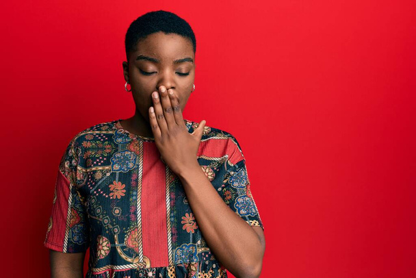 Junge afrikanisch-amerikanische Frau in afrikanischem Stil gelangweilt gähnend müde Mund mit der Hand bedecken. Ruhelos und schläfrig.  - Foto, Bild