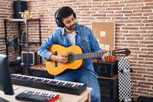 Young arab man musician playing classical guitar at music studio - Foto, Imagem