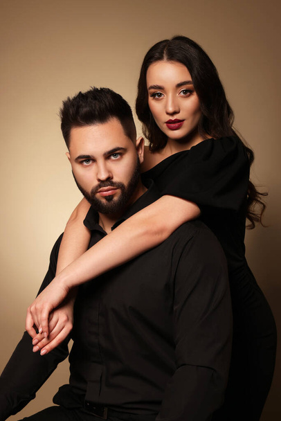 Handsome bearded man with sexy lady on light brown background - 写真・画像