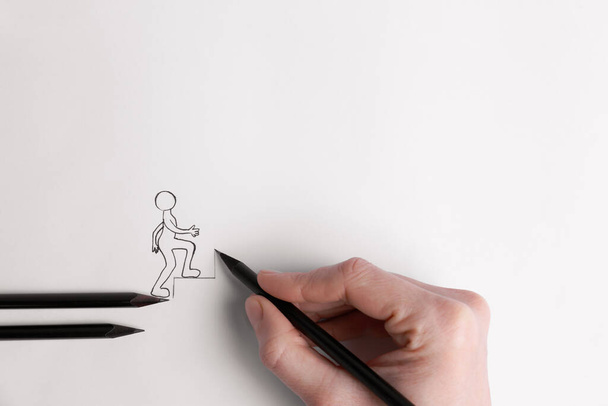 Woman drawing stairs with pencil to help human figure walking up on white background, top view - Fotoğraf, Görsel