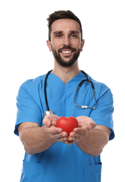 Doctor con estetoscopio y corazón rojo sobre fondo blanco. Concepto de cardiología - Foto, Imagen