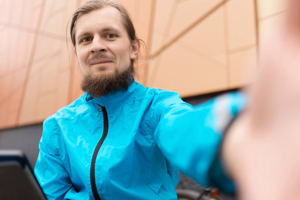 A bearded man in a blue jacket takes a selfie - Foto, Bild