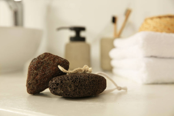 Pumice stones on white countertop in bathroom, closeup. Space for text - Φωτογραφία, εικόνα