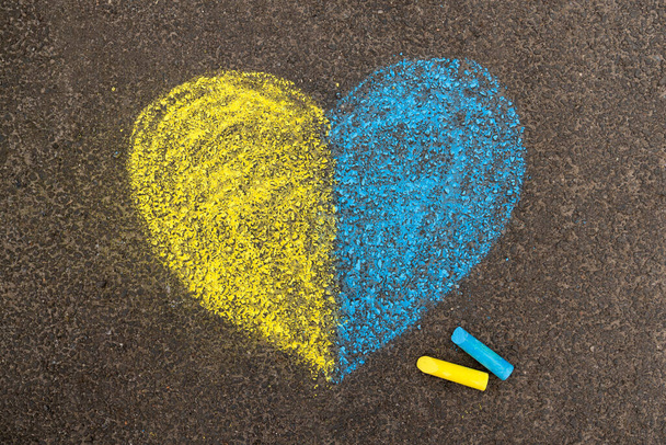 Arrêtez la guerre en Ukraine. Coeur sur le trottoir, dessiné avec des crayons en deux couleurs du drapeau ukrainien jaune et bleu. Photo de haute qualité - Photo, image