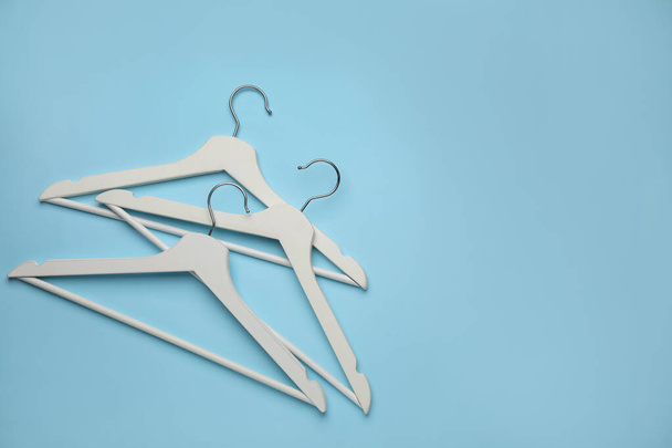 Empty clothes hangers on light blue background, flat lay. Space for text - Valokuva, kuva