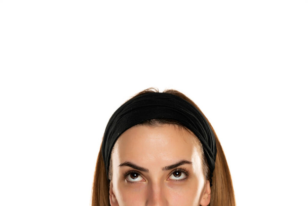 medio retrato de una joven con diadema mirando hacia arriba sobre fondo blanco - Foto, imagen