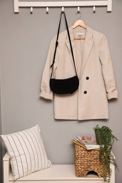 Bench and coat rack on grey wall in hallway. Interior element - Photo, Image
