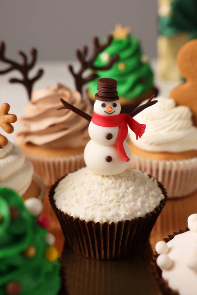 Sabroso cupcake de Navidad con muñeco de nieve en la mesa - Foto, imagen