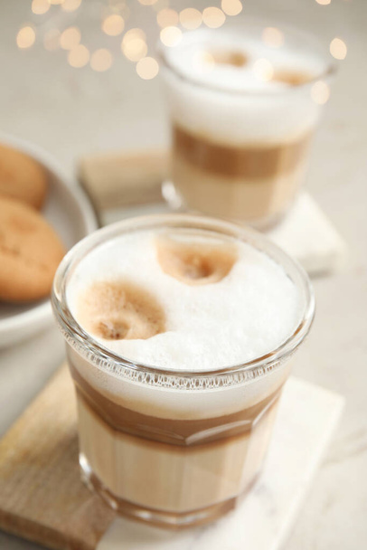 Glasses with delicious latte macchiato on white table - Foto, Imagen