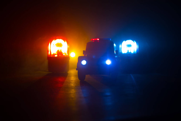 Policejní auto honí v noci auto s mlhou. 911 Pohotovostní reakce Policejní auto uhánějící na místo činu. Kreativní dekorace. Selektivní zaměření - Fotografie, Obrázek