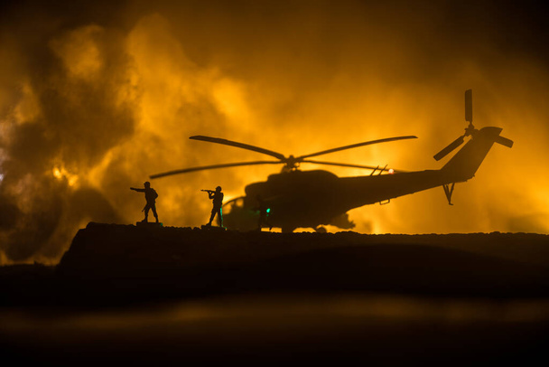 Silhueta de helicóptero militar pronta para voar da zona de conflito. Filmagem noturna decorada com helicóptero começando no deserto com nevoeiro tonificado retroiluminado. Foco seletivo. Conceito de guerra - Foto, Imagem