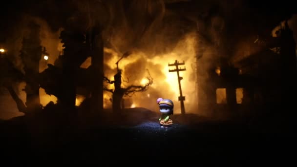 La muerte de los niños en la guerra. La guerra rusa en Ucrania concepto. Obra creativa de muñequita yace en el suelo en la ciudad quemada. Enfoque selectivo   - Metraje, vídeo