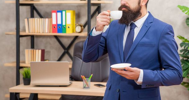 crop brutal ceo in businesslike suit ποτό πρωινό φλιτζάνι καφέ στο γραφείο, επαγγελματίας - Φωτογραφία, εικόνα