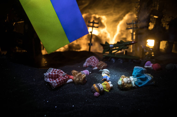 Sodassa kuolleiden lasten. Venäjän sota Ukrainassa käsite. Pienen nuken luova taideteos on maassa palaneessa kaupungissa. Valikoiva painopiste - Valokuva, kuva