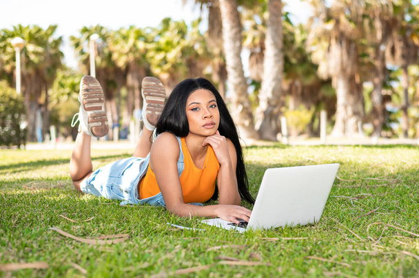 beautiful young woman with laptop in a park - Photo, Image