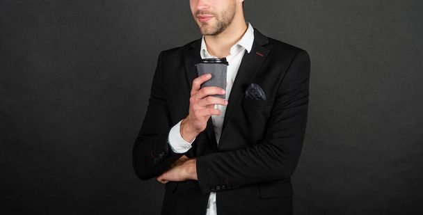 cropped handsome young man in suit with takeaway coffee - Foto, Imagen