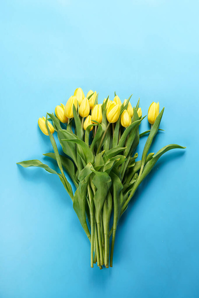 A bouquet of yellow tulips on a blue background - Valokuva, kuva