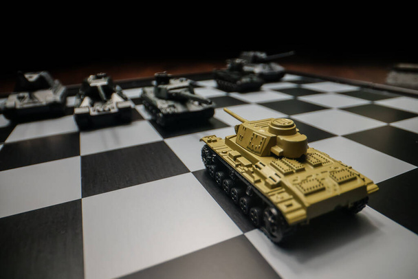 Satranç tahtasındaki oyuncak tanklar. Askeri strateji kavramı. - Fotoğraf, Görsel
