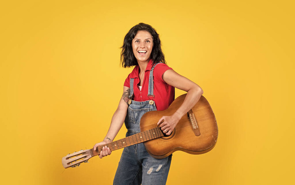 teacher of music. happy beautiful lady playing the guitar. music and vocal. female country singer. cheerful woman sing and play. girl with acoustic guitar instrument. feel happiness and joy - Fotoğraf, Görsel