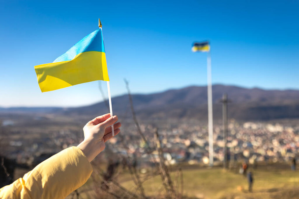 空に対する女性の手でウクライナの旗. - 写真・画像