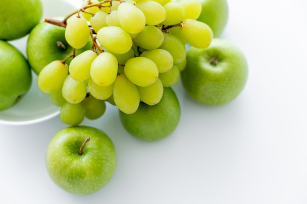 top view of green and ripe apples near grapes on white - Foto, Imagem