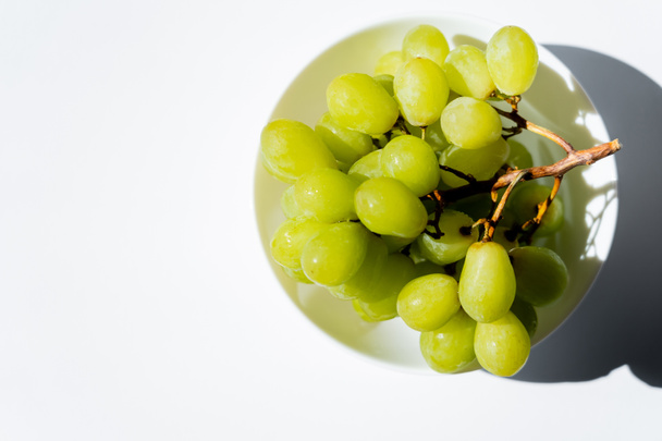 top view of tasty green grapes in bowl on white - Fotoğraf, Görsel